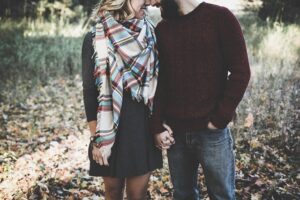 A happy couple walks hand in hand through a park - symbolizing emotional closeness, connection, and the positive outcomes of successful marriage and couples therapy